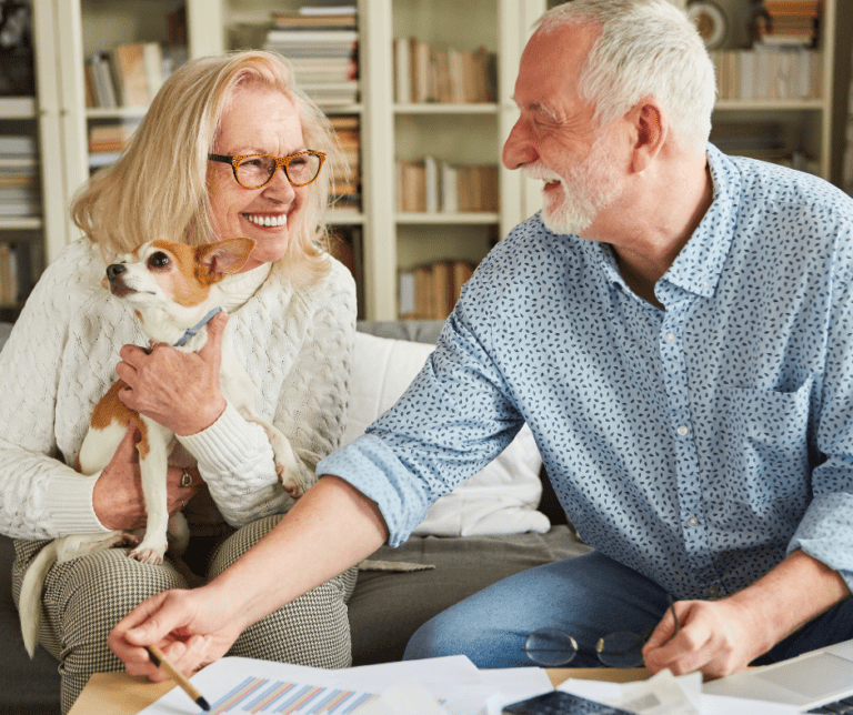Pet Friendly Website Image - Lakes at Woodhaven elderly woman and elderly man in room holding dog